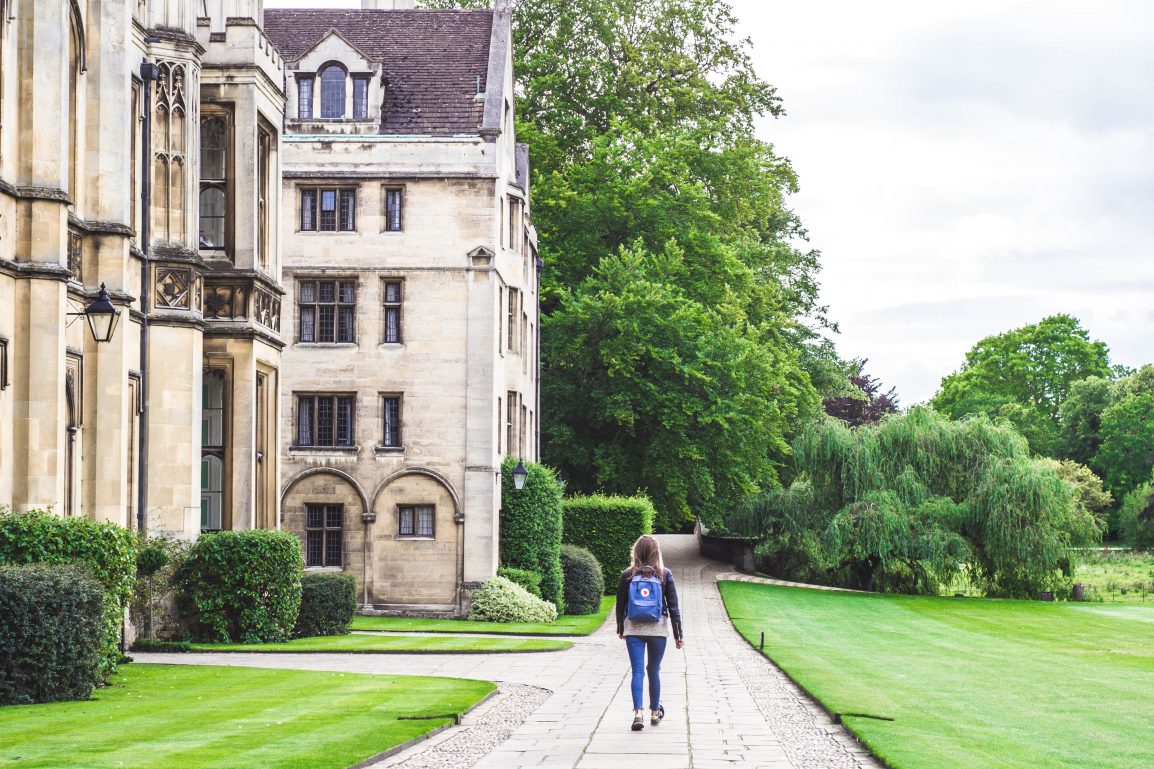 Girl walking through Cambridge campus with a backpack