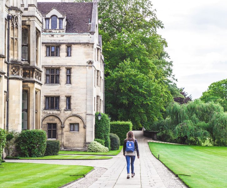 Girl walking through Cambridge campus with a backpack