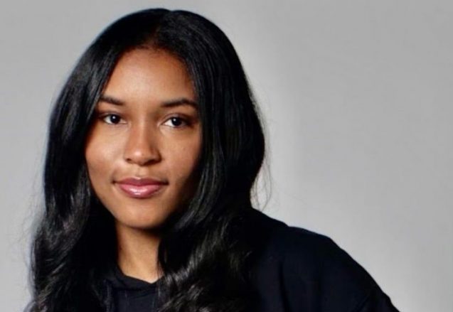 Jordyn Hudson poses wearing a sweatshirt that reads "be the change."