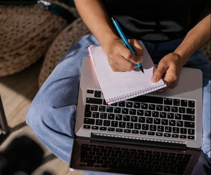 girl taking notes with laptop