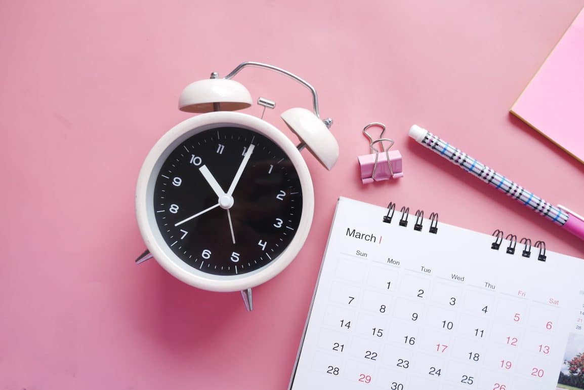 Time-keeping objects on a pink backdrop