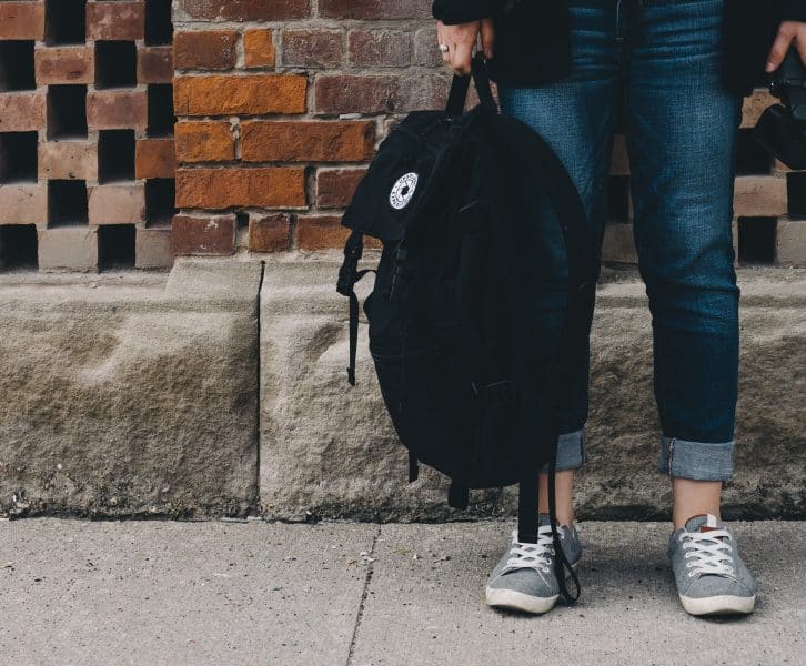 Girl Holding a backpack and a tripod