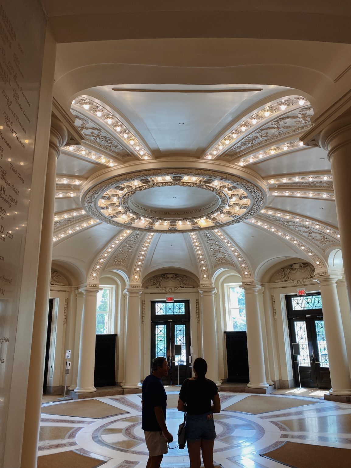 Photo of two people walking in main hallway of building