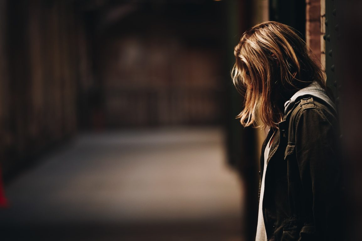 A girl standing alone with her head down