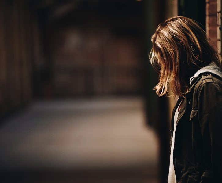 A girl standing alone with her head down