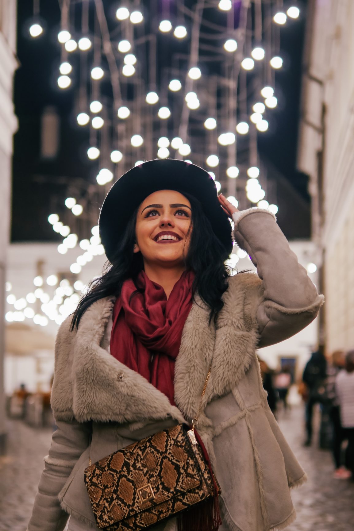 A woman smiling with Christmas decor in the background