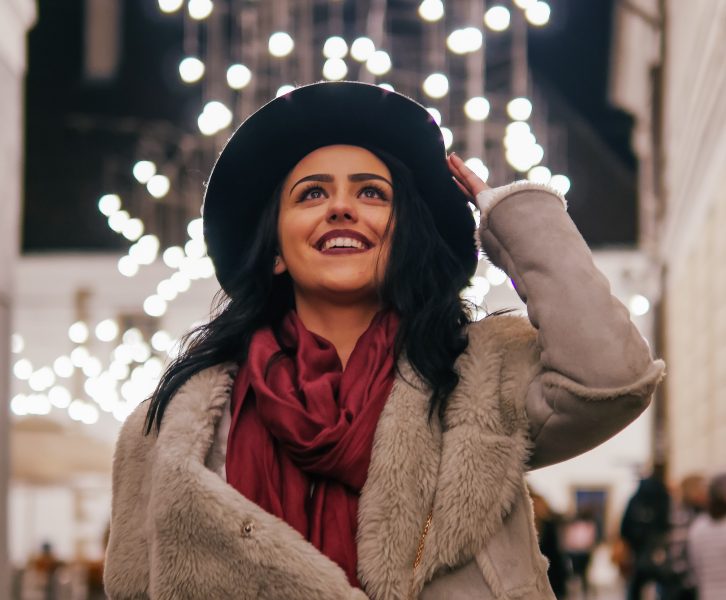 A woman smiling with Christmas decor in the background