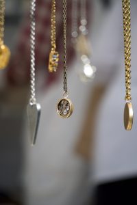 various colored and styles of necklaces hanging in a row