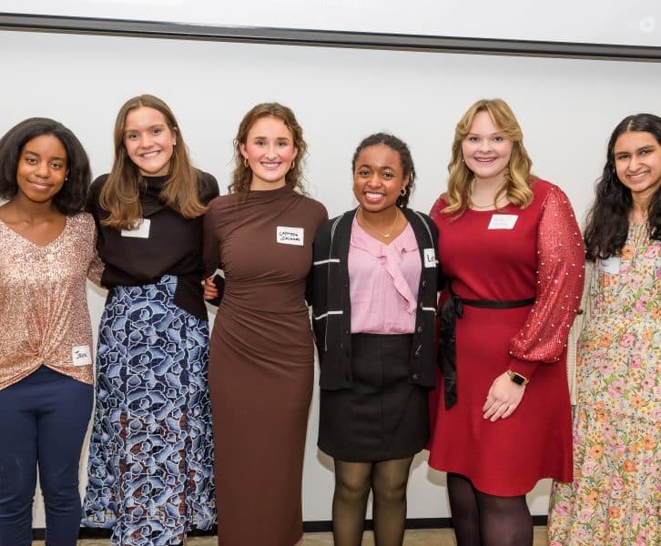 Photo of four young women smiling and standing together in a group, with a sign above them that reads "Meet the Springboarders." The image is related to a Teen Advisory Board.