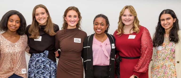 Photo of four young women smiling and standing together in a group, with a sign above them that reads "Meet the Springboarders." The image is related to a Teen Advisory Board.