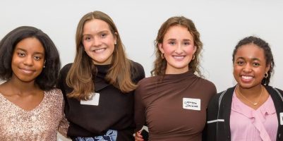 Photo of four young women smiling and standing together in a group, with a sign above them that reads "Meet the Springboarders." The image is related to a Teen Advisory Board.