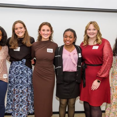 Photo of four young women smiling and standing together in a group, with a sign above them that reads "Meet the Springboarders." The image is related to a Teen Advisory Board.